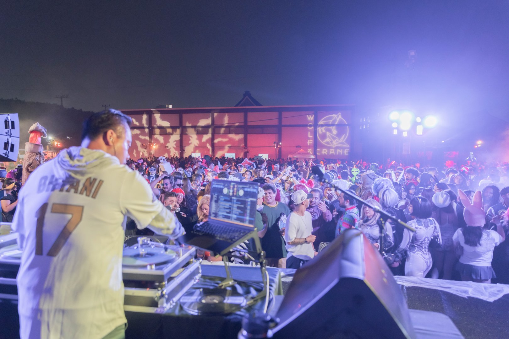 DJ on stage before a massive costumed crowd at Haunted Little Tokyo